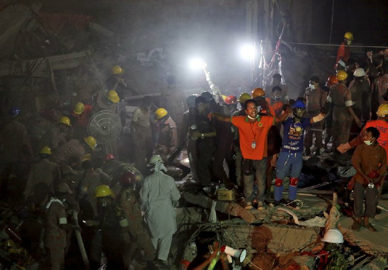 Bangladeshi rescue workers react Sunday after a fire broke out in a tunnel being used to search for survivors in the wreckage of the garment factory that collapsed Wednesday in Savar, near Dhaka, Bangladesh. The fire forced some of the rescue efforts to stop temporarily. 