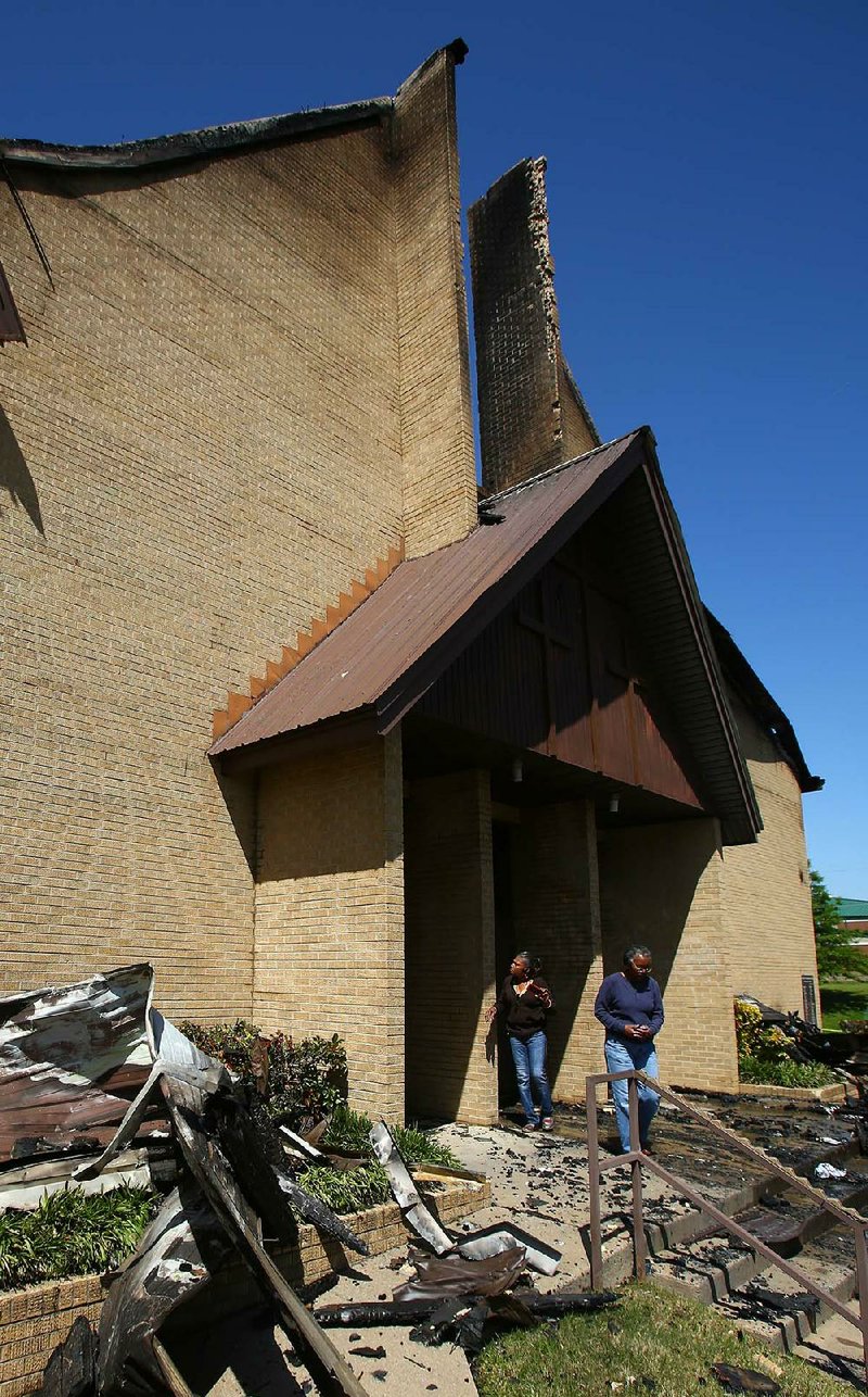 Parishioner Dorsey Gupton (left) and visitor Rita Walton Wells look over fire damage to the front of the First Baptist Church Highland Park at West 18th and Pine streets in Little Rock on Sunday afternoon. An early morning blaze destroyed the church. 