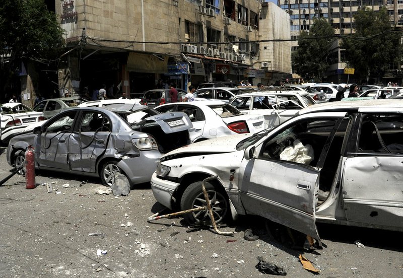 This photo released by the Syrian official news agency SANA, shows vehicles damaged by a powerful explosion which occurred in the central district of Marjeh, in Damascus, Syria, on Tuesday April 30, 2013. 