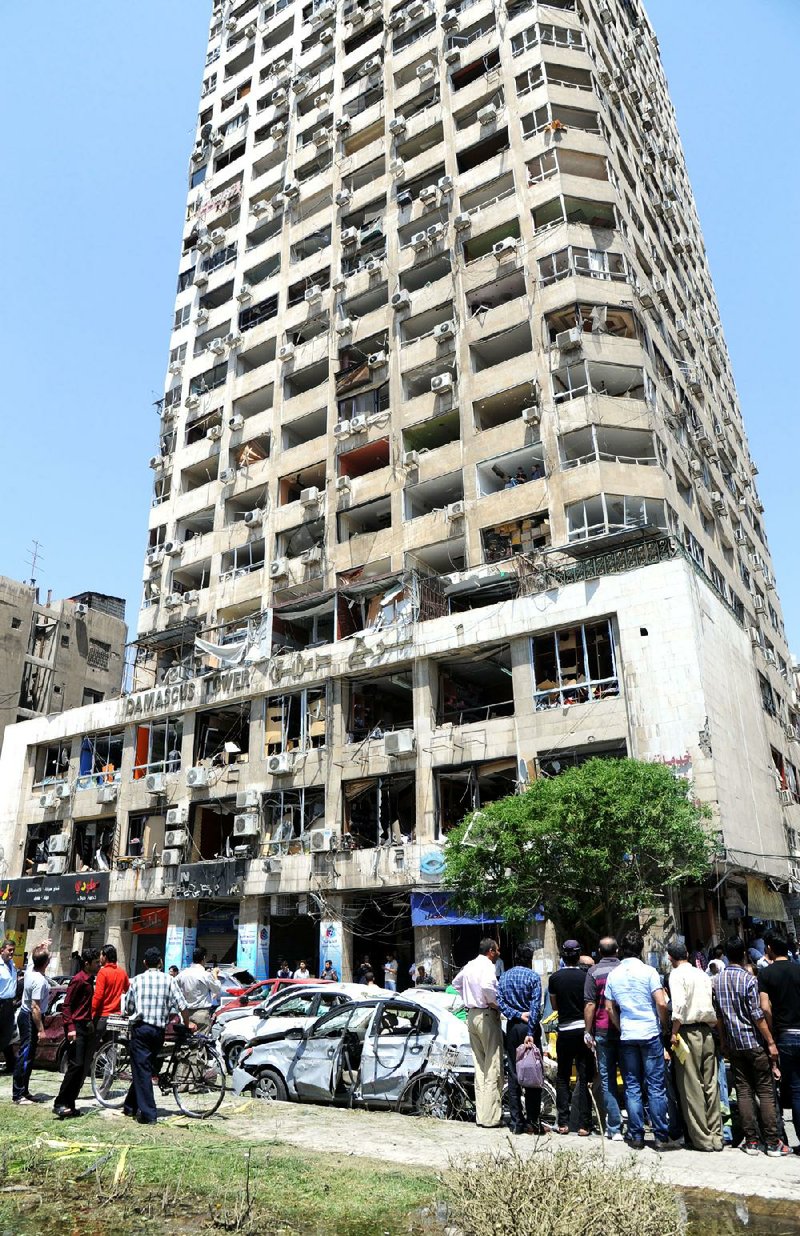 This photo released by the Syrian official news agency SANA, shows a damaged commercial  building after a powerful explosion occurred in the central district of Marjeh, in Damascus, Syria, Tuesday April 30, 2013. A powerful explosion rocked Damascus on Tuesday, causing scores of casualties, a day after the country's prime minister narrowly escaped an assassination attempt in the heart of the heavily protected capital. (AP Photo/SANA)