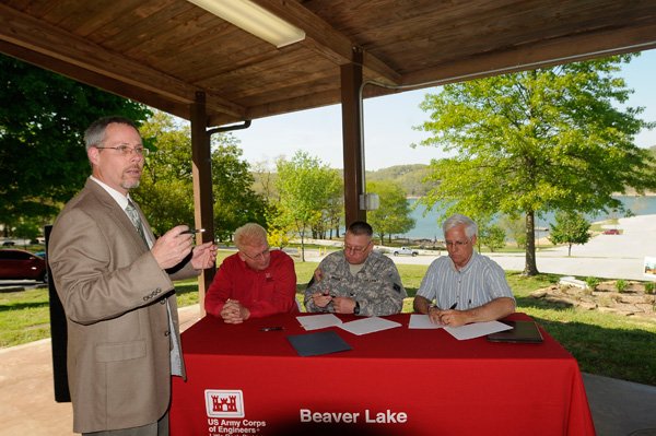Sean Harper, left, Army Corps of Engineers operations manager at Beaver Lake, explains Tuesday aspects of the agreement between the corps and the Beaver Lake Foundation. Signing the document at Prairie Creek park are, from left, John Balgavy and Col. Glen Masset with the corps’ Little Rock District, and Kerry Jensen, president of the Beaver Lake Foundation. 