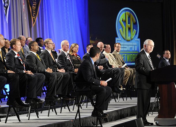 Southeastern Conference Commissioner Mike Slive, right, speaks in front of a large collection of SEC coaches during a news conference announcing the launching of the Southeastern Conference Network in partnership with ESPN, Thursday, May 2, 2013, in Atlanta. The network will produce 1,000 live events each year, including 450 televised on the network and 550 distributed digitally. (AP Photo/John Amis)