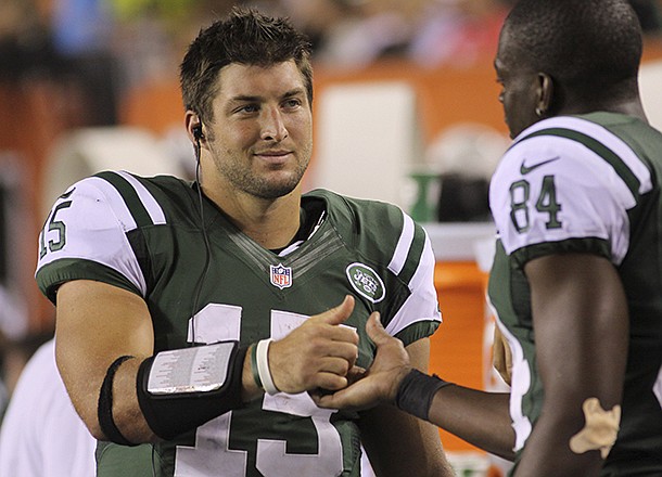 New York Jets quarterback Tim Tebow (15) meets with wide receiver Stephen Hill (84) in the second half of an NFL preseason football game against the Cincinnati Bengals, Friday, Aug. 10, 2012, in Cincinnati. (AP Photo/Tom Uhlman)