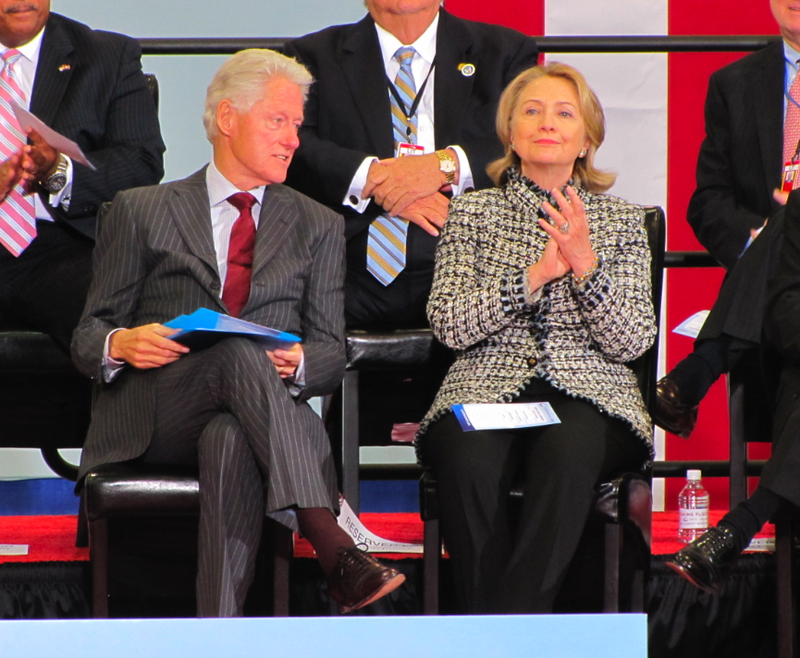 Bill and Hillary Clinton sit on stage during a dedication ceremony for the Little Rock airport named after them.