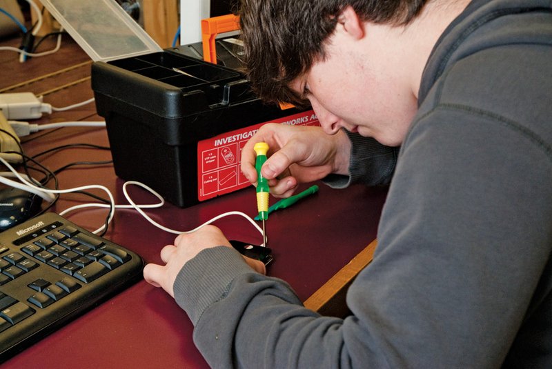 Heber Springs High School junior Matt Woodson replaces a screen on an iPod Touch during a computer class.