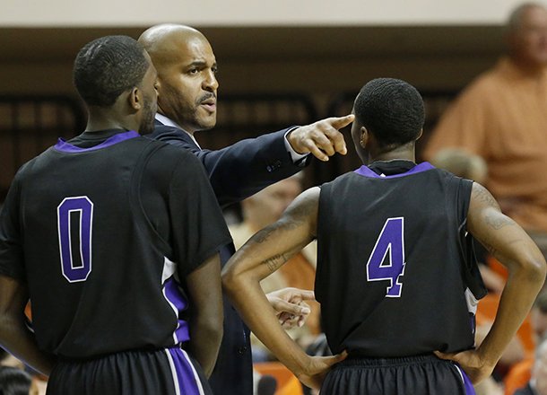 Central Arkansas head coach Corliss Williamson talks to guard Robert Crawford (0) and guard Lenell Brown (4) during the first half of an NCAA college basketball against Oklahoma State game in Stillwater, Okla., Sunday, Dec. 16, 2012. (AP Photo/Sue Ogrocki)