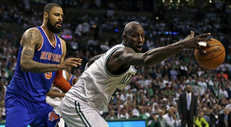 Boston Celtics center Kevin Garnett (right) reaches for the ball in front New York Knicks center Tyson Chandler during Friday’s playoff game in Boston. Garnett had 15 points and 10 rebounds in the loss. 