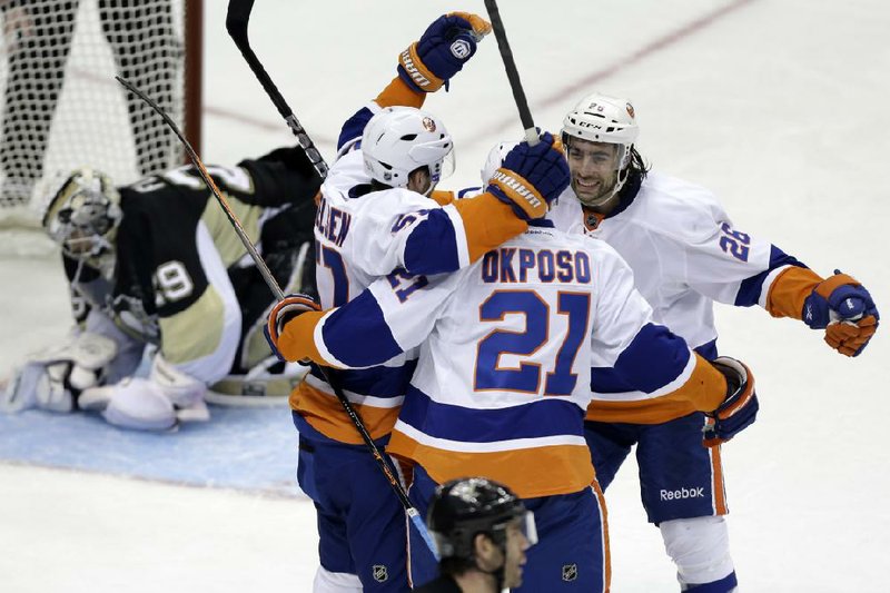 New York Islanders right winger Kyle Okposo (21) celebrates his first career playoff goal with teammates Matt Moulson (26) and Frans Nielsen (51) during the third period of Friday’s NHL playoff game in Pittsburgh. The Islanders, who trailed 2-0 in the first period, won 4-3 to even the series at 1-1. 