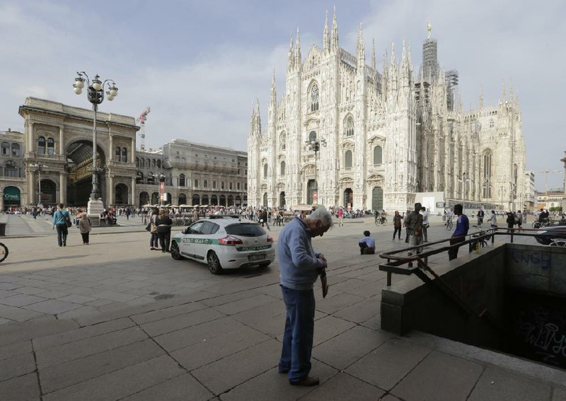 A man checks on his money Thursday near the Duomo cathedral in Milan, Italy. The European Commission warned Friday that the economic outlook for the European Union has deteriorated. 