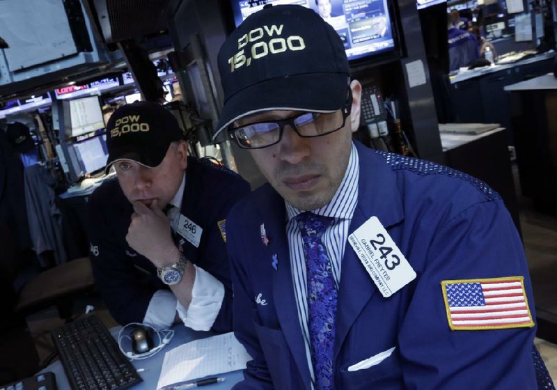 Specialists Devin Cryan (left) and Gabriel Freytes work Friday at a post on the floor of the New York Stock Exchange, where the Dow Jones industrial average crossed 15,000 for the first time. 