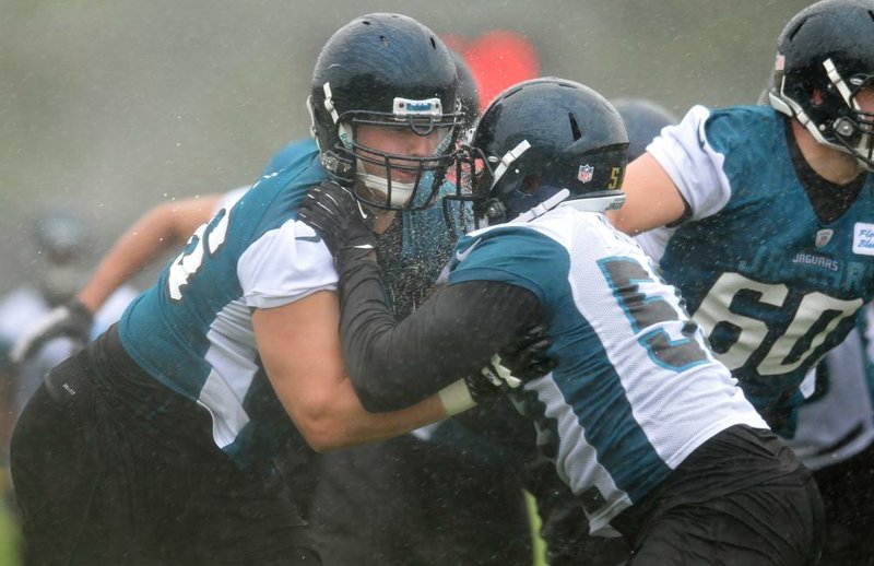Jacksonville Jaguars tackle Luke Joeckel (left) blocks teammate Ryan Davis during a drill Saturday at the team’s rookie mini-camp in Jacksonville, Fla. Joeckel, who played left tackle in college, is having to adjust to playing on the right side of the offensive line. 