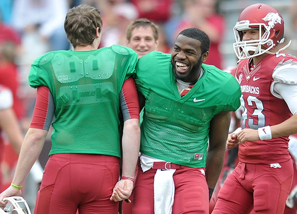 Arkansas quarterback Brandon Mitchell (right) greets quarterback AJ Derby at the end of the 2013 Red-White Scrimmage at Razorback Stadium in Fayetteville.