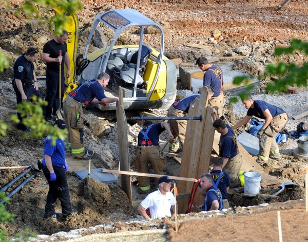 Fayetteville emergency responders work to try to free a man who was trapped in a trench collapse Sunday evening at the Vue, an apartment complex under construction off Stadium Drive in Fayetteville. Responders were called to the scene at 4:57 p.m. 