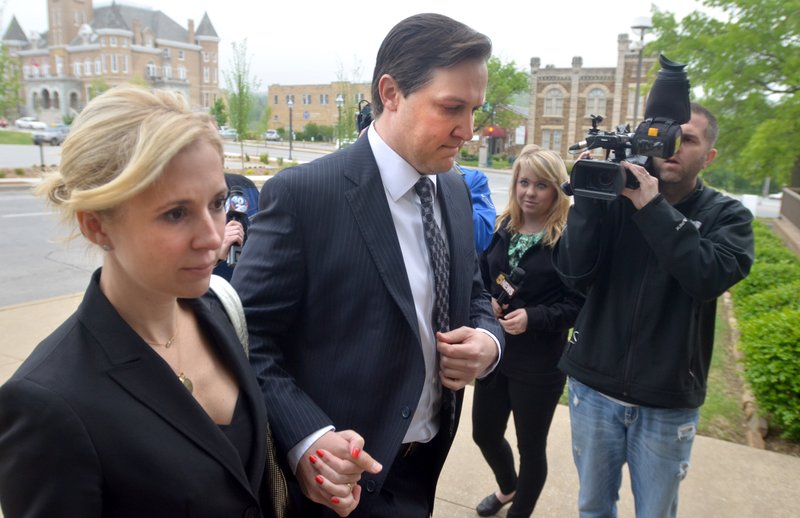 Brandon Barber, center, a former developer, is escorted into the John Paul Hammerschmidt Federal Building in Fayetteville by  Kristen Foodim, left, Monday, May 6th, 2013, in Fayetteville. Barber has been charged with 27 counts of conspiracy and wire, bank and bankruptcy fraud.