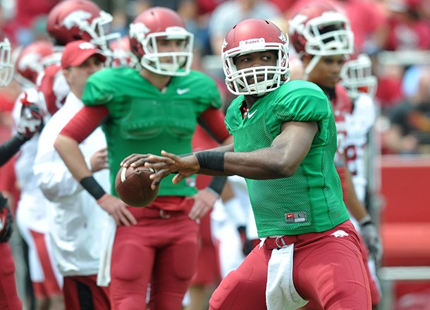 Arkansas quarterback Brandon Mitchell throws while Brandon Allen looks on during the 2013 Red-White scrimmage at Razorback Stadium in Fayetteville.