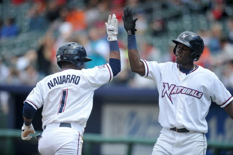 Northwest Arkansas Naturals third baseman Rey Navarro (left) is congratulated by teammate Orlando Calixte after he hit a two-run home run against the Arkansas Travelers on Sunday in Springdale. 