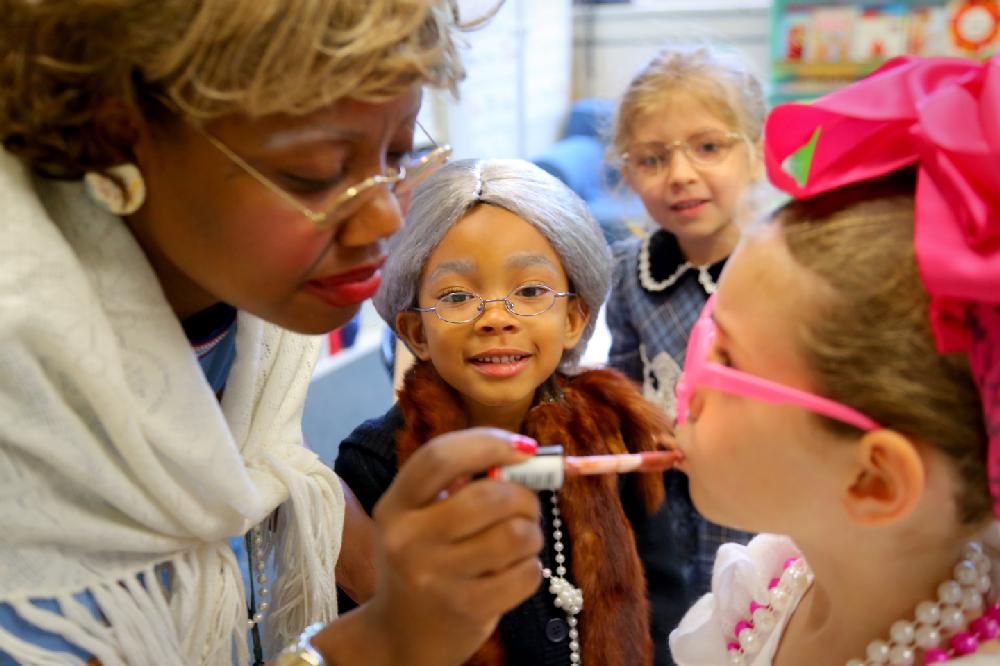 5/8/13
Arkansas Democrat-Gazette/STEPHEN B. THORNTON
Forrest Park Elementary pre-kindergartens  Zoey Burl, center, and , Haighlee Dorris second from right, watch as  teacher Miyen Williams, left, applies lip gloss to Haven Roberts, right, Wednesday morning at the Little Rock school. The pre-K students and teachers were dressed as if they were 100 years old to film a humorous talent show video to help commemorate the 100th anniversary of the school.