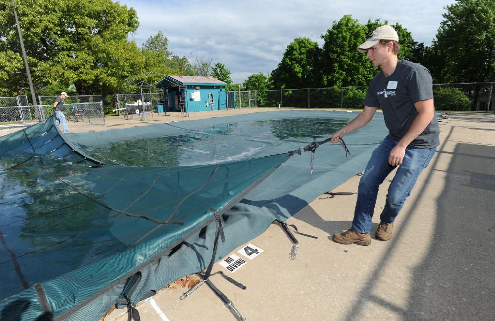 NWA Media ANDY SHUPE
Erik Drews, grounds director at the Mount Sequoyah Retreat and Conference Center in Fayetteville, right, and Matt Stauffacher, a worker at the center, work Wednesday, May 8, 2013, to pull the cover from the center's pool. The center offers several passes to the public to enjoy the pool, which is open 5 a.m. until midnight daily May 17 through Sept. 30. Visit mountsequoyah.org for more information.