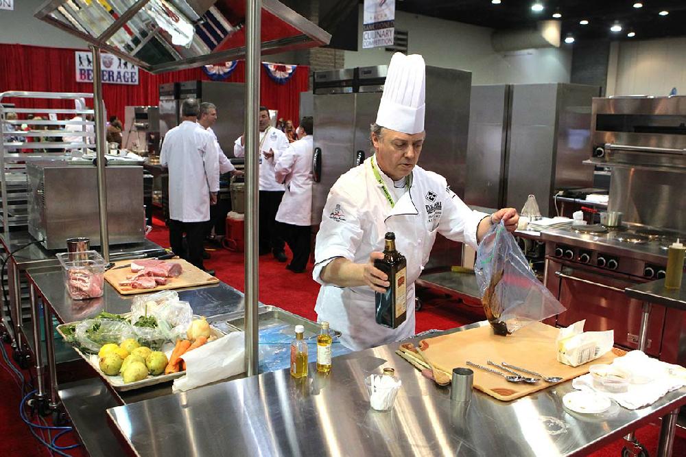 Chef Philippe Ducrot of Hot Springs Village works on a pork dish during an American Culinary Federation competition at the Ben E. Keith foodshow at the Hot Springs Convention Center Wednesday, May 8, 2013. (The Sentinel-Record/Ricahrd Rasmussen