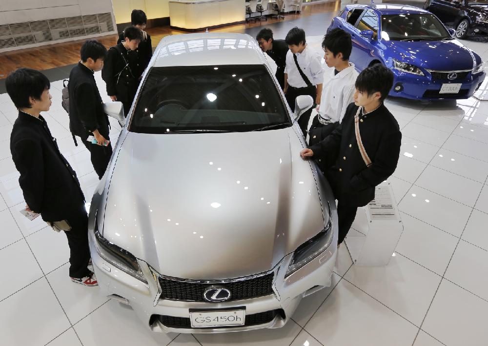 School boys look at a Lexus GS450h displayed at the Toyota Motor Corp. showroom Toyota Mega Web in Tokyo Wednesday, May 8, 2013. Toyota's January-March profit more than doubled to 313.9 billion yen ($3.2 billion) as cost cuts and better sales worked with a weakening yen to add momentum to the automaker's comeback. (AP Photo/Itsuo Inouye)