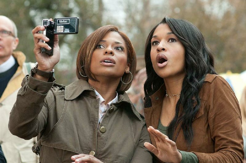 Meg (Kimrie Lewis-Davis) and Gloria (Kali Hawk) document the goings-on at the Peeples’ family gathering in Tina Gordon Chism’s comedy Peeples. 