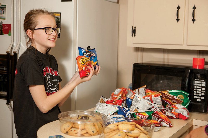 Gracie James, 11, selects snacks from the table at the Searcy K-Life house. The ministry moved to its current location nine months ago.