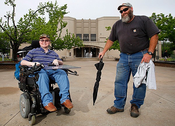 University of Arkansas student Raymond Walter, 18, and his father, Hal Walter, spend time on campus in Fayetteville. Hal Walter has been his son’s caregiver on campus for the past four years. 