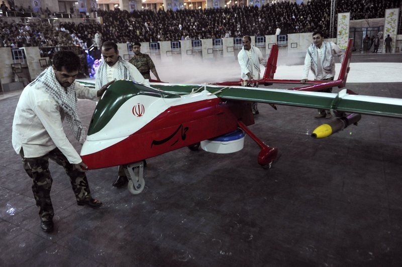 In this picture released by the Iranian Students News Agency, men move the Epic drone, painted with the Iranian flag colors, during a ceremony in Tehran, Iran, Thursday, May 9, 2013. Iran's defense minister says Iran has built a new, radar-evading drone that can do surveillance and fire on enemy targets. The semi-official Fars news agency on Thursday quoted Gen. Ahmad Vahidi as saying that the new aircraft _ dubbed Epic, or Hemaseh in Farsi _ can fly at high altitudes. In recent years, Iran has been pursuing a drone program alongside its military program that has aimed to produce missiles, jet fighters, destroyers, light submarines and torpedoes.