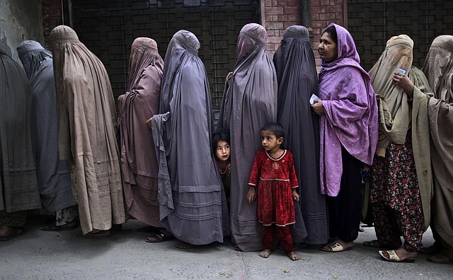 Pakistani women wait Saturday to enter a polling station on the outskirts of Islamabad. Voters turned out in large numbers despite attacks on candidates, party workers and voters that left scores of people dead. 