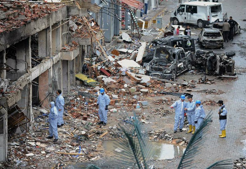 Police forensic officers work at the scene at one of the Saturday explosion sites that killed 46 and injured about 50 others, in Reyhanli, near Turkey's border with Syria, Sunday, May 12, 2013.  The bombings on Saturday marked the biggest incident of cross-border violence since the start of Syria's bloody civil war and has the raised fear of Turkey being pulled deeper into the conflict.(AP Photo)