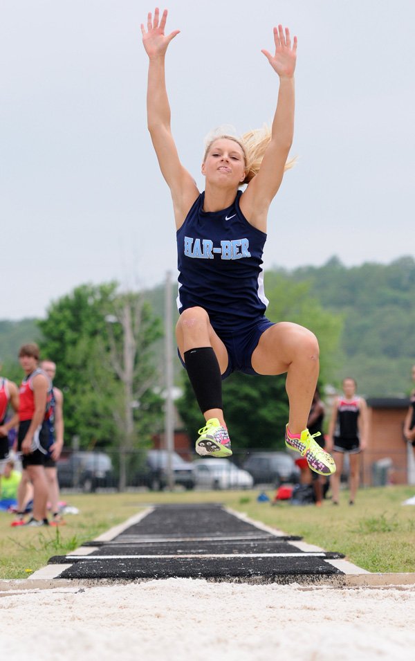 Payton Stumbaugh reaches up high during her long jump attempt Wednesday at the Ramay Junior High School track and field complex in Fayetteville during Day 1 of the decathlon and heptathlon state meets. 
