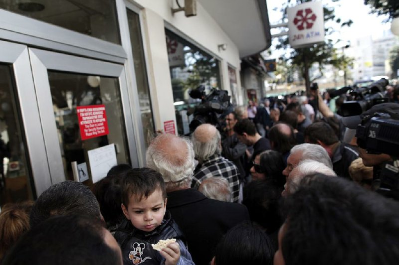 People wait outside a branch of Laiki Bank in Nicosia, Cyprus, in late March, when efforts to engineer a financial bailout for the country proved chaotic for European officials. 