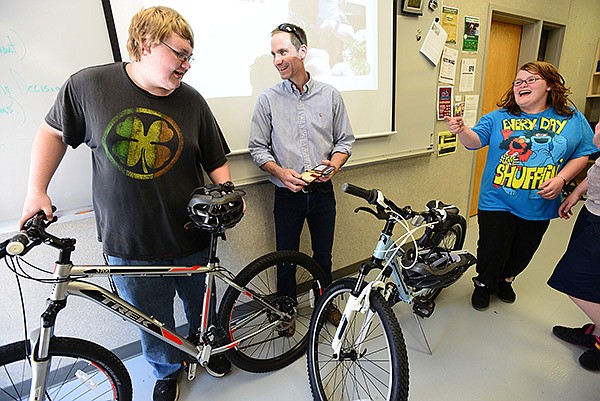Bryon Moudy, center, master fit technician for Phat Tire Bike Shop, presents Coulter Fitzner, 17, and Breanna Swadley, 16, with new Trek mountain bikes Friday, May 17, 2013, during their small business operations class at Bentonville High School. The students were awarded the bicycles by Moudy for their class attendance history and completing a 3-part essay.