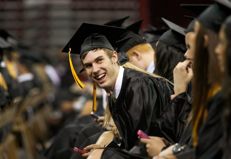 Colton Frost, a Bentonville graduate, smiles toward the audience Saturday during Bentonville High School's commencement inside Bud Walton Arena in Fayetteville. 