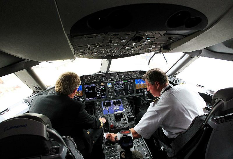 United's pilots Niels Olufsen, left, and Bill Blocker, right, prepare the cockpit while parked at gate E7 at Bush Intercontinental Airport for the first flight back for the Dreamliner, Monday, May 20, 2013, in Houston.  (AP Photo/Houston Chronicle, Karen Warren)