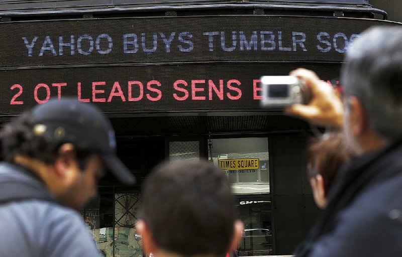 A news headline about the Tumblr sale to Yahoo scrolls on a building in New York's Times Square,  Monday, May 20, 2013. Yahoo is buying online blogging forum Tumblr for $1.1 billion as CEO Marissa Mayer tries to rejuvenate an Internet icon that had fallen behind the times. (AP Photo/Richard Drew)