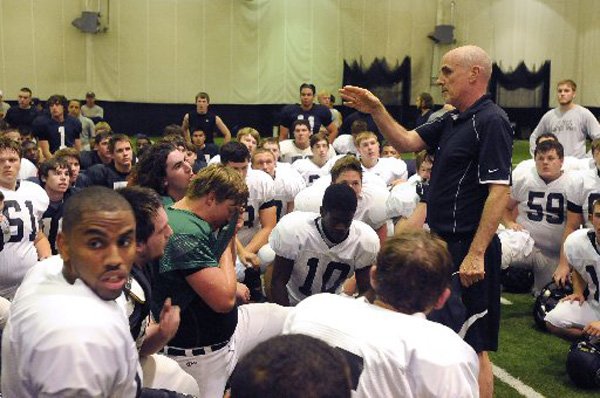 Barry Lunney, Bentonville head football coach, instructs his players to take shelter Monday inside the school’s field house as dangerous storms move into the area postponing a scrimmage. 