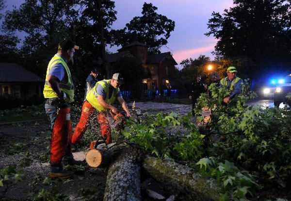 Workers from the Bentonville Street Department use chain saws to cut down and clear a tree which broke off and fell into East Central Avenue at 305 E. Central Ave. in Bentonville. Strong wind from a storm ripped through Northwest Arkansas and prompted a tornado watch at 7:40 p.m. by the National Weather Service Storm Prediction Center in Norman, Okla. 