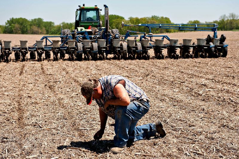 Farmer Bill Maupin verifies his planter is dropping corn seeds at the appropriate depth as he plants a field outside of Henry, Illinois, U.S., on Tuesday, May 14, 2013. Corn and soybeans fell Wednesday for a second day in Chicago on speculation planting will accelerate as the U.S. Midwest has drier weather this week following the slowest start to spring fieldwork since the 1980s. Photographer: Daniel Acker/Bloomberg  *** Local Caption *** Bill Maupin