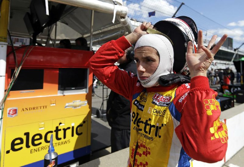 Carlos Munoz, of Colombia, puts on his helmet as he prepares to drive during practice for the Indianapolis 500 auto race at the Indianapolis Motor Speedway in Indianapolis, Sunday, May 12, 2013. (AP Photo/Darron Cummings)