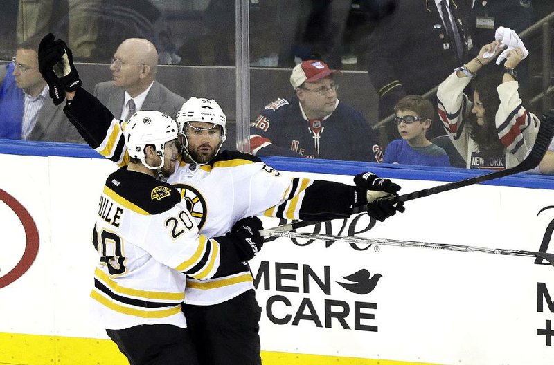 Boston Bruins' Johnny Boychuk, right, and Daniel Paille (20) celebrate a goal by Boychuk during the third period in Game 3 of the Eastern Conference semifinals in the NHL hockey Stanley Cup playoffs Tuesday, May 21, 2013, in New York. Paille later scored the game-winner. The Bruins won 2-1 and lead the best-of-seven games series 3-0. (AP Photo/Frank Franklin II)