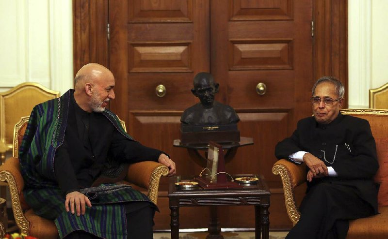 Indian President Pranab Mukherjee, right, listens to Afghan President Hamid Karzai during a meeting at the Indian Presidential Palace in New Delhi, India, Tuesday, May 21, 2013. Karzai is meeting with Indian leaders and is expected to seek increased military aid from India. India has invested more than $2 billion in Afghan infrastructure, including highways and hospitals and rural electricity projects. India is helping the Afghan government rebuild its police forces, judiciary and diplomatic services. (AP Photo/Manish Swarup)