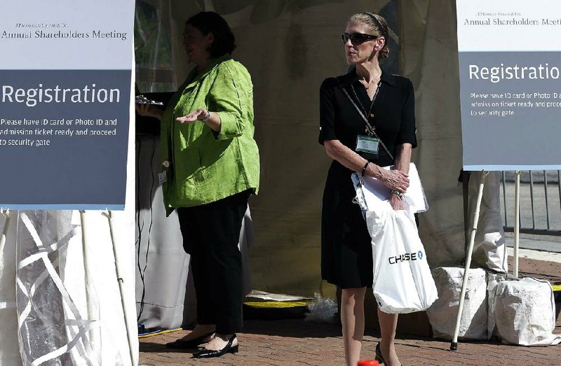 Receptionists greet stockholders as they arrive for the JPMorgan annual meeting Tuesday, May 21, 2013, in Tampa, Fla. Jamie Dimon, the chairman and CEO of JPMorgan Chase, said Tuesday that last year's $6 billion trading loss had been expensive and "extremely embarrassing" but he also asked shareholders not to fixate on the issue. (AP Photo/Chris O'Meara)