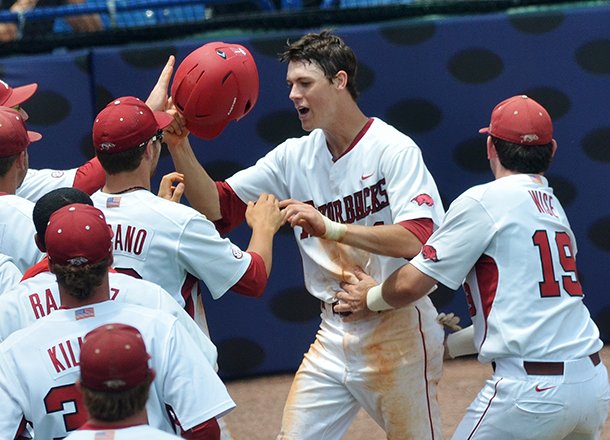 Arkansas outfielder Brian Anderson is greeted by teammates after scoring the winning run on a wild pitch in the 10th inning of Wednesday morning's game against Ole Miss in the 2013 SEC baseball tournament in Hoover, Ala. 