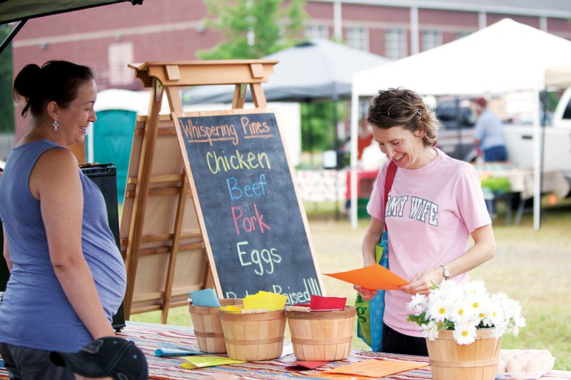 Amanda Sellers, left, chats with Brenda Parry while she shops at the Conway Farmers Market.