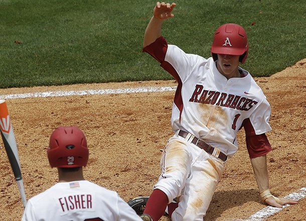 Arkansas' Brian Anderson slides into home on a wild pitch in the tenth inning of their Southeastern Conference tournament college baseball game against Arkansas at the Hoover Met in Hoover, Ala., Wednesday, May 22, 2013. Arkansas beat Mississippi 2-1 after the play. At front is Arkansas' Eric Fisher (29). (AP Photo/Dave Martin)
