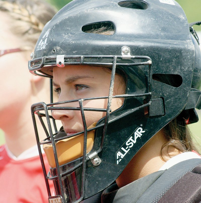 Harding Academy catcher Shelby Gowen listens to instructions from her coach during a recent game. Heat causes risks for athletes, as a rise in temperature can increase health concerns.