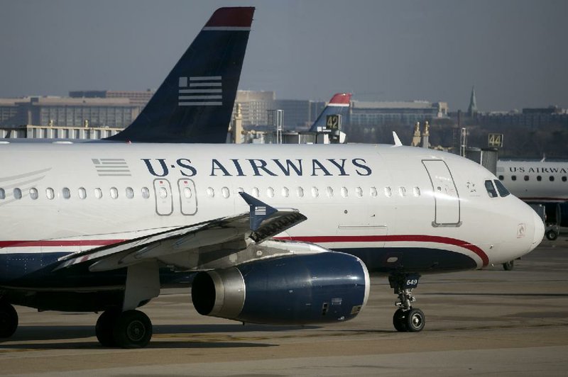 A US Airways jet taxis at Reagan National Airport in Virginia, in this file photo. Arkansas officials want US Airways to keep all of its slots at Reagan National if the airline’s merger with American Airlines is approved, to ensure that direct flights between Little Rock and Washington continue. 