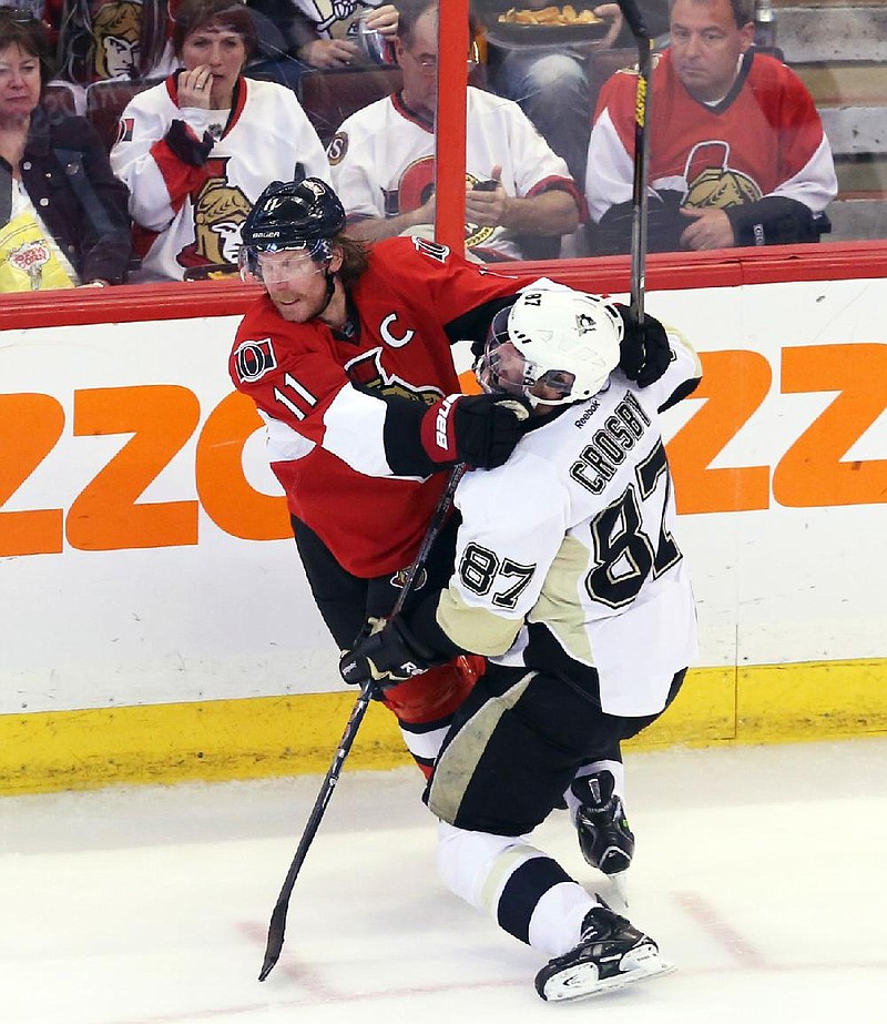 Sidney Crosby (right) of the Pittsburgh Penguins is checked by Daniel Alfredsson of the Ottawa Senators during the Penguins’ 7-3 victory Wednesday night. 