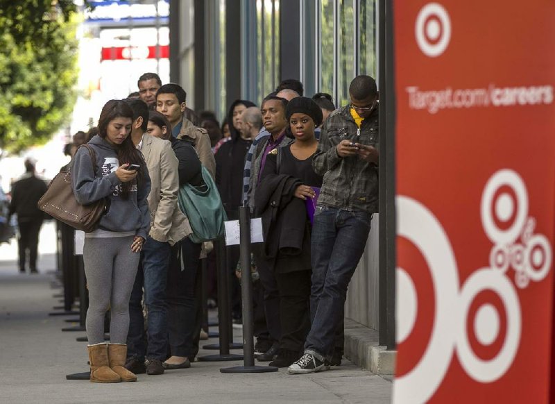Job seekers line up outside a Target store in Los Angeles in January. Target on Wednesday reported a first-quarter profit of $498 million, down from $697 million a year ago. 